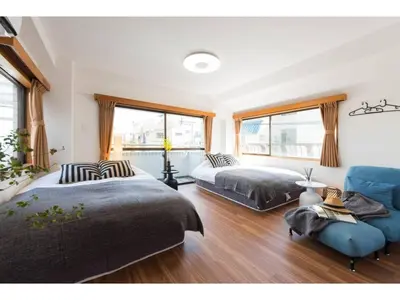 a bedroom with two beds and a blue couch at Tora Hotel Rikugien - Vacation STAY 52744v in Tokyo