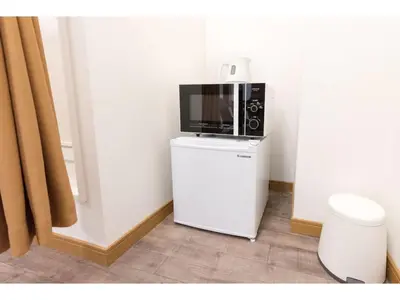a microwave sitting on top of a white refrigerator at Tora Hotel Rikugien - Vacation STAY 52726v in Tokyo