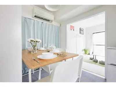 a dining room with a wooden table and white chairs at Tora Hotel Kitaueno - Vacation STAY 52747v in Tokyo