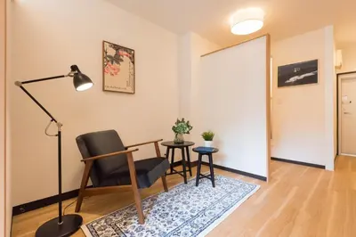 a living room with a table and a chair and a lamp at Tora Hotel Ueno - Vacation STAY 52809v in Tokyo