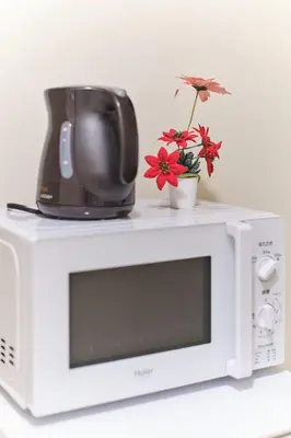 a microwave with a coffee pot and flowers on top of it at Tora Hotel Ueno - Vacation STAY 52806v in Tokyo