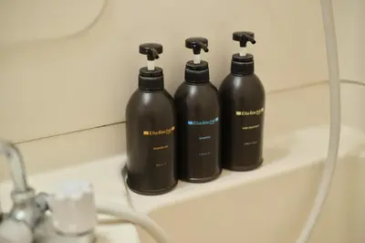 three black bottles sitting on a shelf in a bathroom at Tora Hotel Ueno - Vacation STAY 52811v in Tokyo