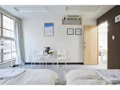 a bedroom with two beds and a table and a door at Tora Hotel Taito - Vacation STAY 53048v in Tokyo