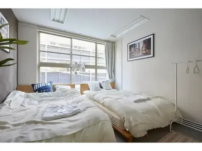 two beds in a room with a window at Tora Hotel Taito - Vacation STAY 53053v in Tokyo
