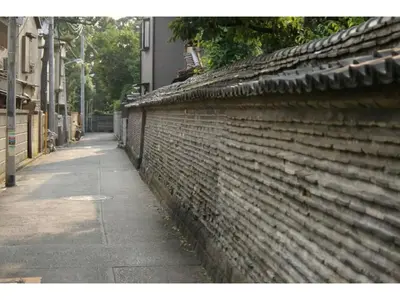 a brick wall next to a sidewalk next to a street at Tora Hotel Taito - Vacation STAY 53053v in Tokyo