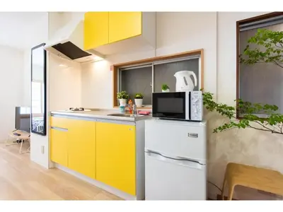 a kitchen with yellow cabinets and a white refrigerator at Tora Hotel Taito - Vacation STAY 53094v in Tokyo