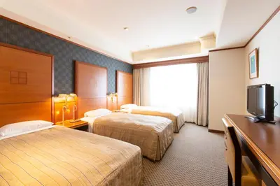 a hotel room with two beds and a television at Hotel Le Port Kojimachi in Tokyo