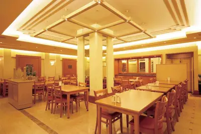 a restaurant with wooden tables and chairs and a whiteboard at Hotel Le Port Kojimachi in Tokyo