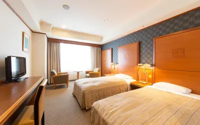 a hotel room with two beds and a flat screen tv at Hotel Le Port Kojimachi in Tokyo