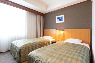 a hotel room with two beds and a window at Hotel Le Port Kojimachi in Tokyo
