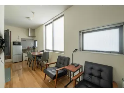 a living room with a table and chairs and a kitchen at bmj Hyakunincho - Vacation STAY 46879v in Tokyo