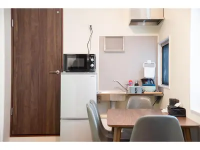 a kitchen with a refrigerator and a table with chairs at bmj Hyakunincho - Vacation STAY 46879v in Tokyo