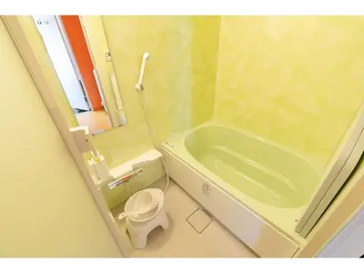 a bathroom with a green tub and a toilet at bmj Shinjuku Okubo - Vacation STAY 46884v in Tokyo