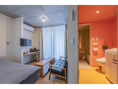 a bedroom with a bed and a desk and a bathroom at bmj Shinjuku Okubo - Vacation STAY 46885v in Tokyo