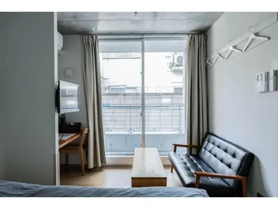 a living room with a couch and a window at bmj Shinjuku Okubo - Vacation STAY 46885v in Tokyo