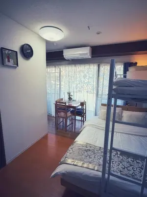 a bedroom with a bunk bed and a dining room with a table at Uhome Ueno Hotel in Tokyo