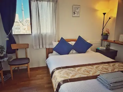 a bedroom with a bed and a chair and a window at Uhome Ueno Hotel in Tokyo