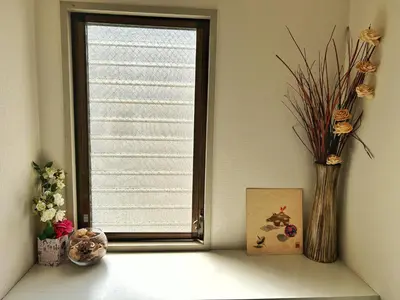 a window with a vase of flowers on a shelf at Uhome Ueno Hotel in Tokyo