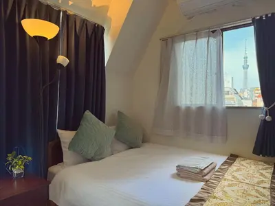 a bedroom with a large bed with a window at Uhome Ueno Hotel in Tokyo