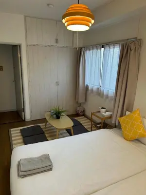 a bedroom with a large bed and a living room at Uhome Ueno Hotel in Tokyo