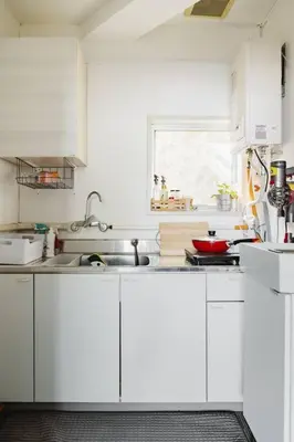 a kitchen with white cabinets and a sink and a window at \u3055\u304f\u3089\u30a4\u30f3\u99c5\u524d\u7652\u3084\u3057\u7a7a\u9593 in Tokyo