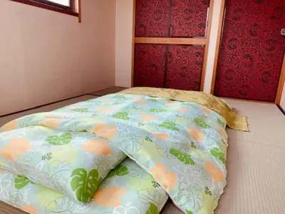a bed in a room with a colorful blanket on the floor at Ostay Numabukuro Hotel Apartment in Tokyo