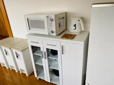 a white kitchen with a microwave and a counter at Ostay Numabukuro Hotel Apartment in Tokyo