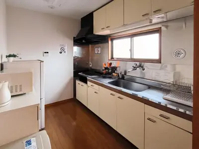 a kitchen with white cabinets and a sink and a window at Ostay Numabukuro Hotel Apartment in Tokyo