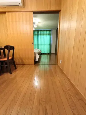 a room with a wooden floor and a room with a bed at Ostay Numabukuro Hotel Apartment in Tokyo