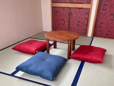 a room with a table and two red pillows at Ostay Numabukuro Hotel Apartment in Tokyo