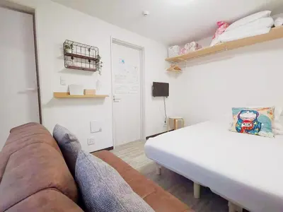 a living room with a couch and a bed at YUYU-Yo-3 --Self Check-in -- Room Number & Password is in the following email in Tokyo
