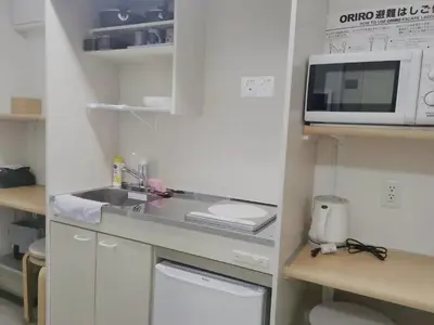 a small kitchen with a sink and a microwave at YUYU-Yo-3 --Self Check-in -- Room Number & Password is in the following email in Tokyo