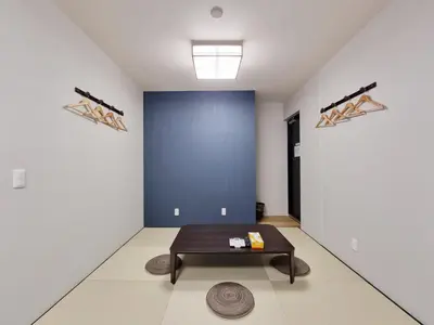 a room with a table and a blue wall at KYU KYU HOTEL in Tokyo