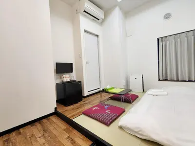 a white bedroom with a bed and a table at KYU KYU HOTEL in Tokyo