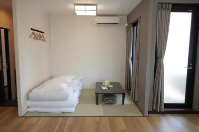 a living room with a bed and a table at KYU KYU HOTEL in Tokyo