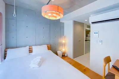 a bedroom with a large white bed in a room at japan house nishishinjuku in Tokyo