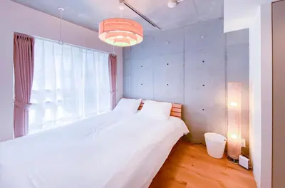 a bedroom with a white bed and a large window at japan house nishishinjuku in Tokyo