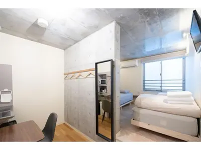 a bedroom with a bed and a desk and a mirror at bmj Hyakunincho - Vacation STAY 68273v in Tokyo