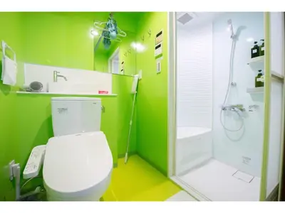 a green bathroom with a toilet and a shower at bmj Hyakunincho - Vacation STAY 68270v in Tokyo