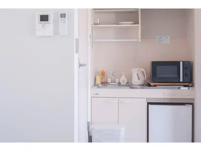 a small kitchen with a microwave and a counter top at bmj Shinjuku Okubo - Vacation STAY 68278v in Tokyo