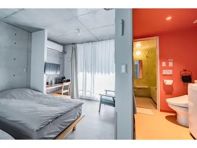 a bedroom with a bed and a bathroom with a sink at bmj Shinjuku Okubo - Vacation STAY 68282v in Tokyo