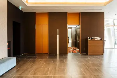 a lobby with orange and black walls and tile floors at Keisei Richmond Hotel Tokyo Oshiage in Tokyo