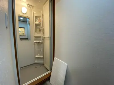a bathroom with a shower and a door to a room at \u30ef\u30f3\u30cf\u30a6\u30b9\u65b0\u5c0f\u5ca9 in Tokyo