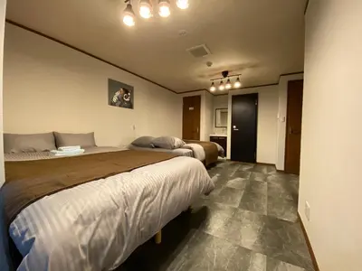 a hotel room with two beds and a hallway at \u30ef\u30f3\u30cf\u30a6\u30b9\u65b0\u5c0f\u5ca9 in Tokyo