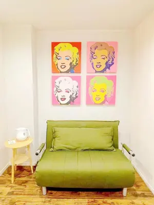 a green bed in a room with pictures on the wall at Hotel Tiffany in Tokyo
