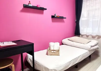 a room with a pink wall with two beds at OHANA TOKYO HOUSE - Vacation STAY 71468v in Tokyo