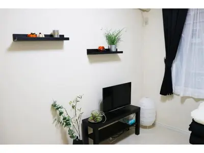 a living room with a tv on a wall at OHANA TOKYO HOUSE - Vacation STAY 71476v in Tokyo