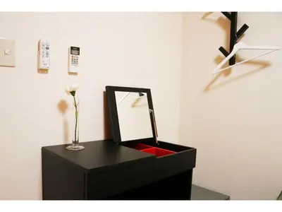 a black vanity with a mirror and a vase with a flower at OHANA TOKYO HOUSE - Vacation STAY 73215v in Tokyo