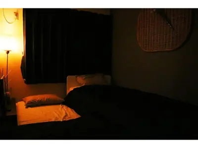 a dark room with a bed and a lamp at OHANA TOKYO HOUSE - Vacation STAY 73655v in Tokyo