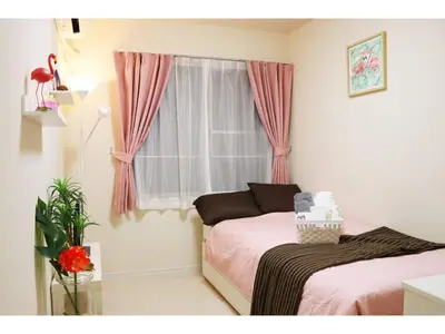 a bedroom with two beds and a window with pink curtains at OHANA TOKYO HOUSE - Vacation STAY 71661v in Tokyo